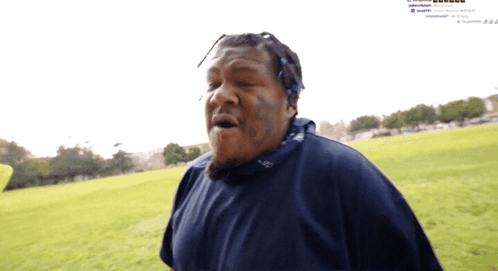 Man With Face Tattoo in Grassy Field