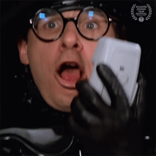 Man with Glasses and Badge Talking on Phone