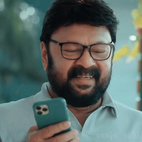 Man with Glasses and Beard Holding Cell Phone