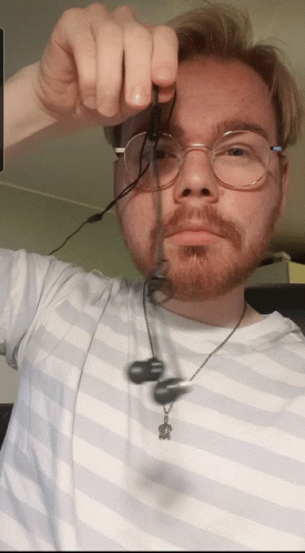 Man With Glasses And Beard Holding Earbuds GIF
