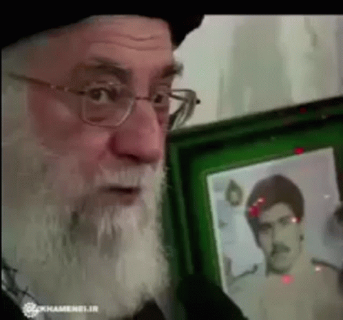 Man With Glasses and Beard Holding Framed Mustache Man