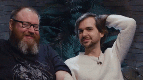Man With Glasses And Beard Next To Man With Pentagram Shirt GIF