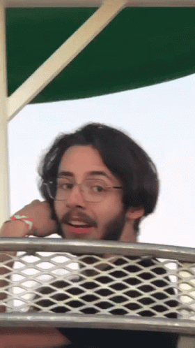 Man with Glasses and Beard Over Wire Fence