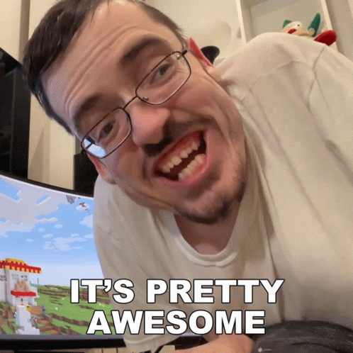 Man With Glasses and Beard Says It's Pretty Awesome in Front of Computer Monitor
