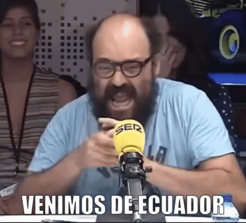 Man With Glasses and Beard Screaming Into Yellow Microphone