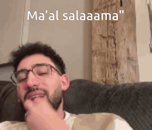 Man With Glasses and Beard Sitting on Couch Ma 'Al Salaama