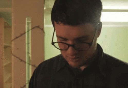 Man With Glasses and Black Shirt Looking Down