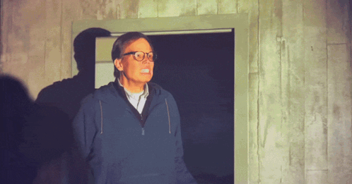 Man with Glasses and Blue Sweatshirt in Doorway