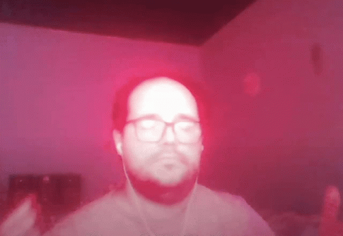 Man With Glasses And Ear Buds On Red Background GIF