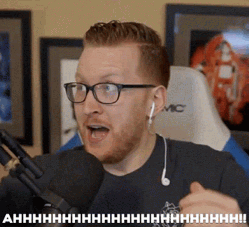 Man With Glasses and Ear Buds Talking Into Microphone Saying Ahhhh