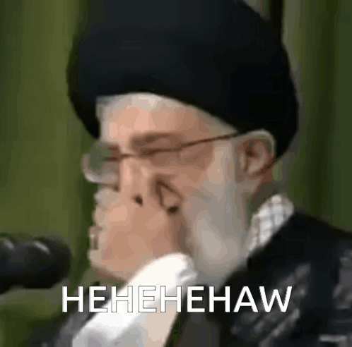 Man With Glasses and Hat Holding Nose Laughing