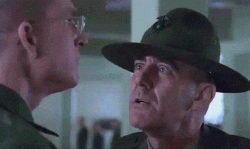 Man With Glasses And Hat Looking At Another Man GIF