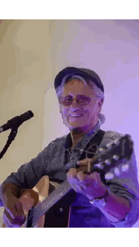 Man with Glasses and Hat Playing Guitar