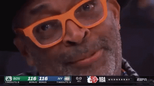 Man With Glasses and Hat Smiling at Basketball Game