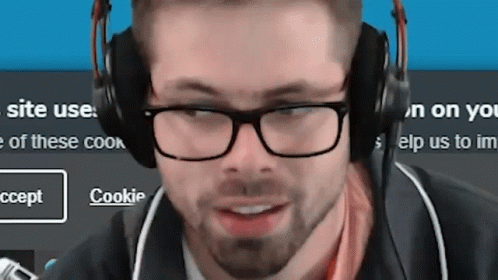 Man With Glasses and Headphones Smiling at Cookie Screen