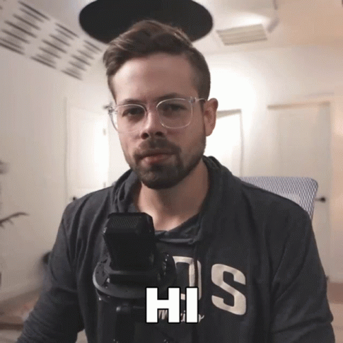Man With Glasses and Hoodie His Talking Into Microphone