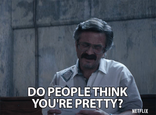 Man With Glasses and Mustache Holding Paper Do People Think You're Pretty