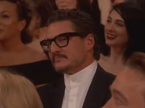 Man With Glasses and Mustache Sitting in Crowd