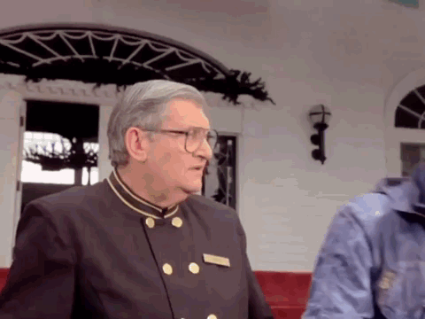 Man With Glasses And Name Tag At White Building GIF