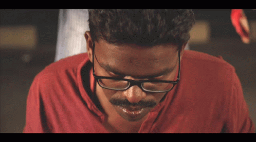 Man With Glasses And Red Shirt Looking Down