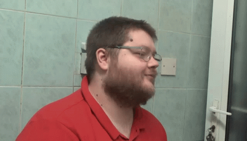 Man with Glasses and Red Shirt Standing by Door