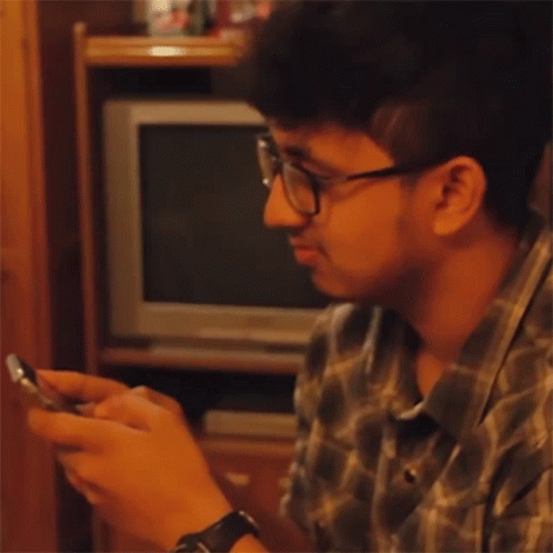 Man With Glasses And Watch Looking At Cell Phone GIF