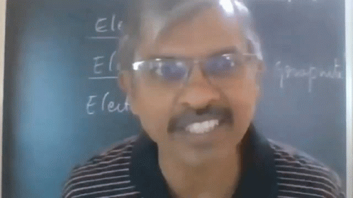 Man With Glasses at Blackboard Saying Electro