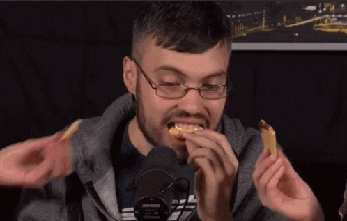 Man With Glasses Eating at Microphone