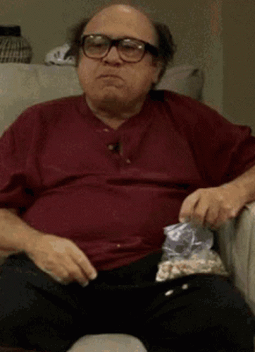 Man With Glasses Eating Popcorn On Couch GIF
