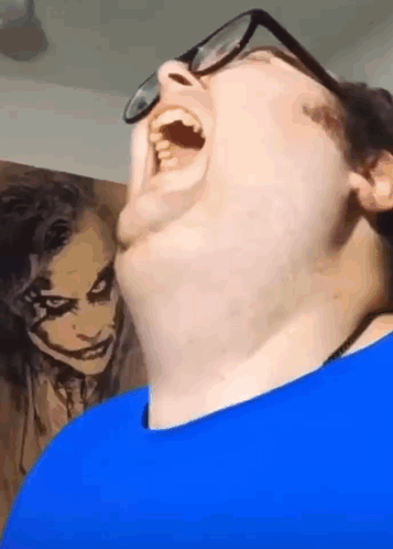 Man with Glasses Funny Face in Front of Joker Painting