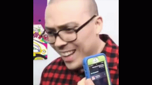 Man With Glasses Holding Cell Phone Smiling
