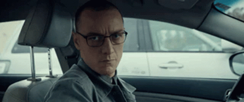 Man With Glasses in Driver's Seat Looking at Camera
