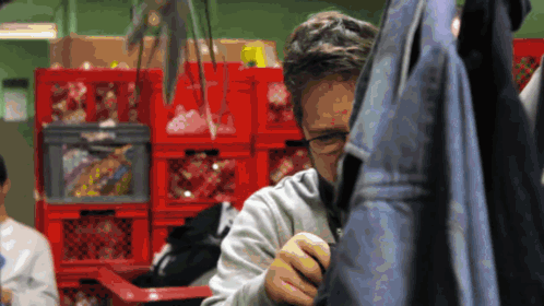 Man With Glasses in Front of Red Crates