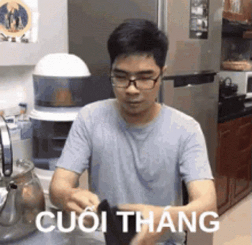 Man With Glasses in Kitchen Foreign Language Shirt