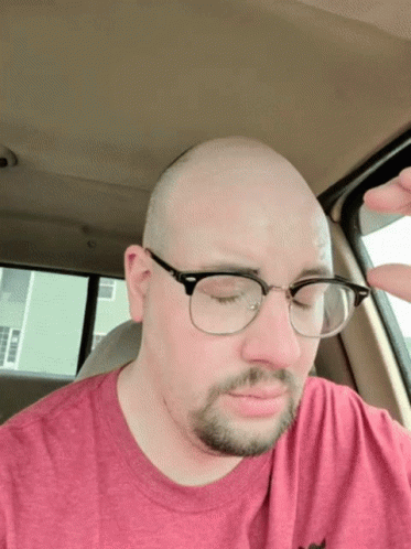 Man With Glasses in Red Shirt Eyes Closed in Car
