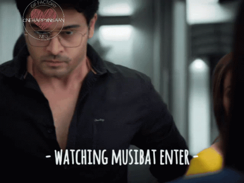Man With Glasses Next to Woman Watching Musibat Enter