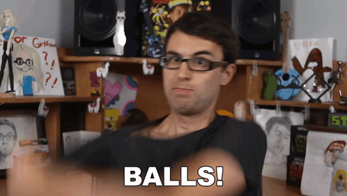 Man With Glasses Says Balls in Front of Stuffed Animals Desk
