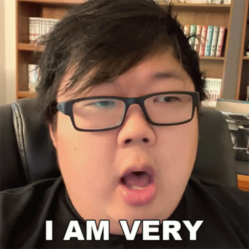 Man With Glasses Says I Am Very In Front Of Bookshelf GIF