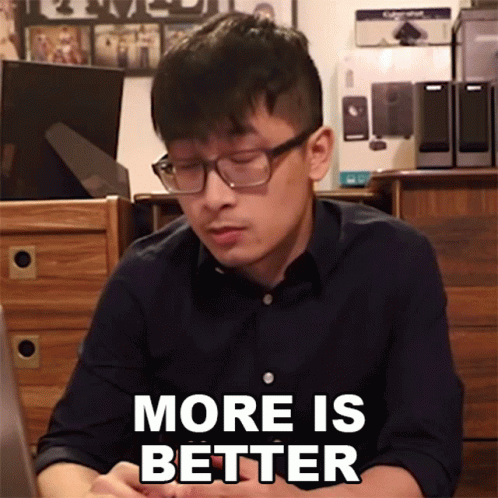 Man with Glasses Sitting at Desk More Is Better