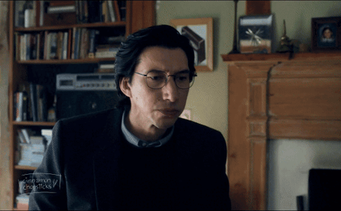 Man With Glasses Sitting By Fireplace GIF