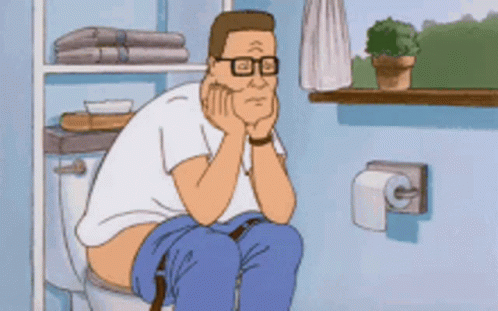 Man with Glasses Sitting on Toilet