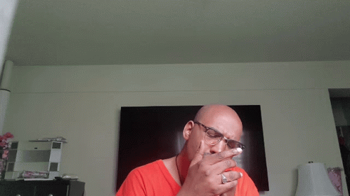 Man With Glasses Smoking Cigarette in Front of TV