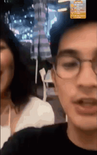 Man With Glasses Talking To Woman In Blurry Photo GIF