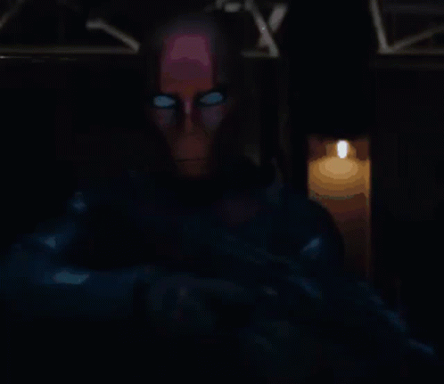 Man With Glowing Eyes Standing By Lit Candle GIF