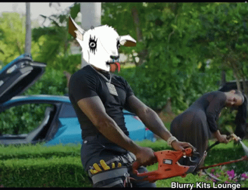 Man With Goat Mask Holding Black and Decker Hedge Trimmer