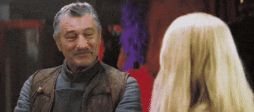 Man With Gray Hair and Mustache Talking to Blonde Woman