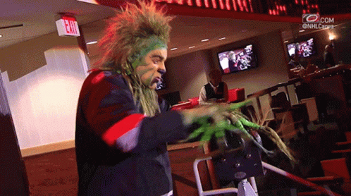 Man with Green Face Paint and Red Exit Sign