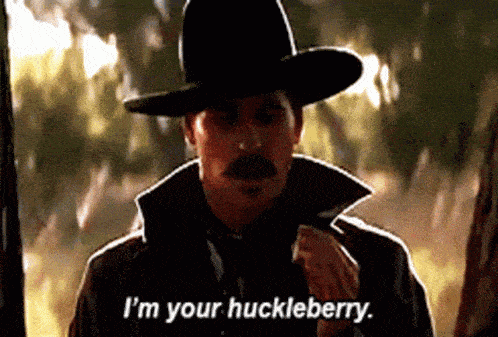 Man With Gun And American Flag Saying I'm Your Huckleberry GIF