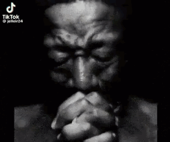 Man with Hands Folded in Front of Face