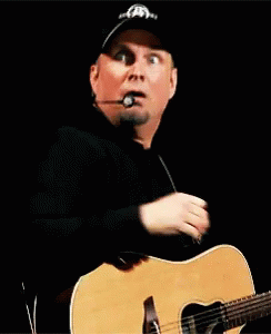 Man With Hat And Microphone Holding Guitar GIF